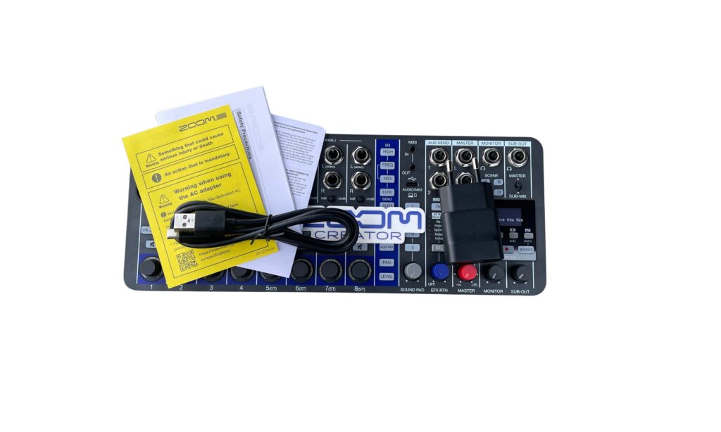 Der Lieferumfang umfasst ein Netzteil, USB-C Kabel und Zoom Aufkleber